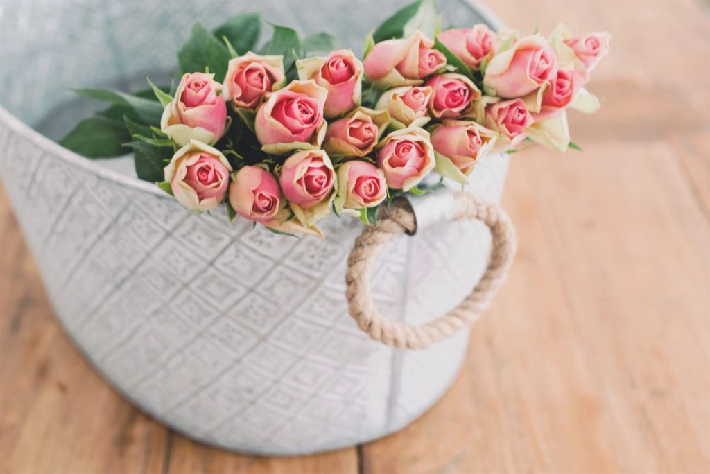 a basket with pink Valentine's Day Flowers