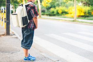 child waiting for school bus