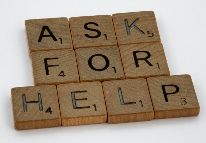 "Ask For Help" spelled out on scrabble game tiles