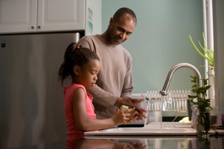 Father and daughter talking while washing dishes