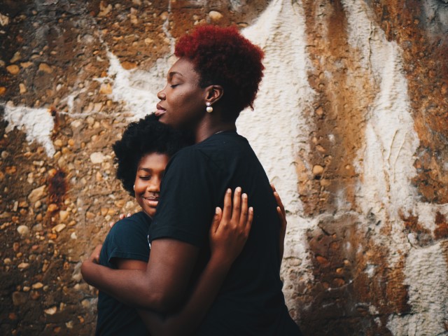 African American mother hugging child close to reassure in scary times